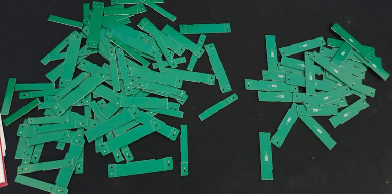 Ein großer Haufen grüner PCB-Nutzenstege, übrig nach dem Vereinzeln von 30 Boards.