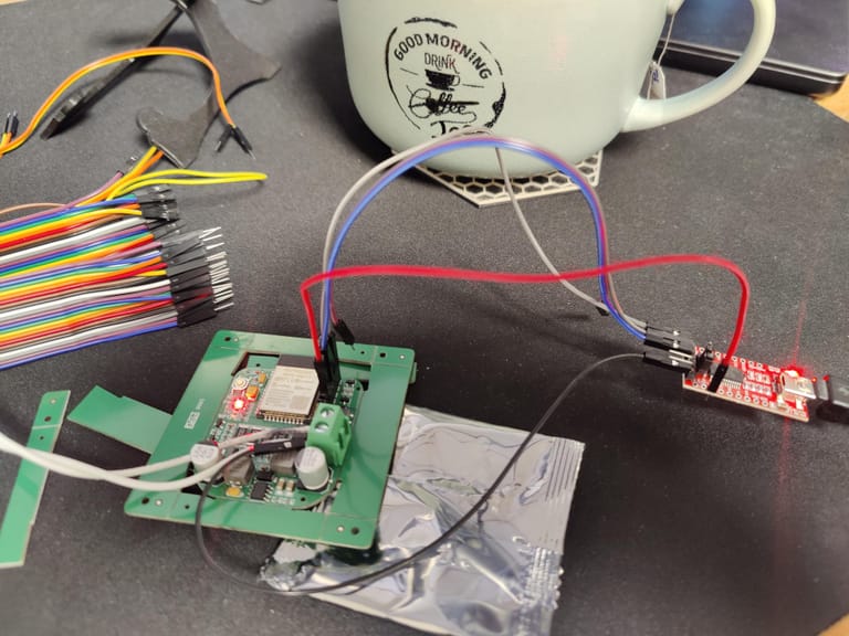 Die ESP32-Platine wird über einen USB-Seriell-Adapter auf dem Schreibtisch geflasht.