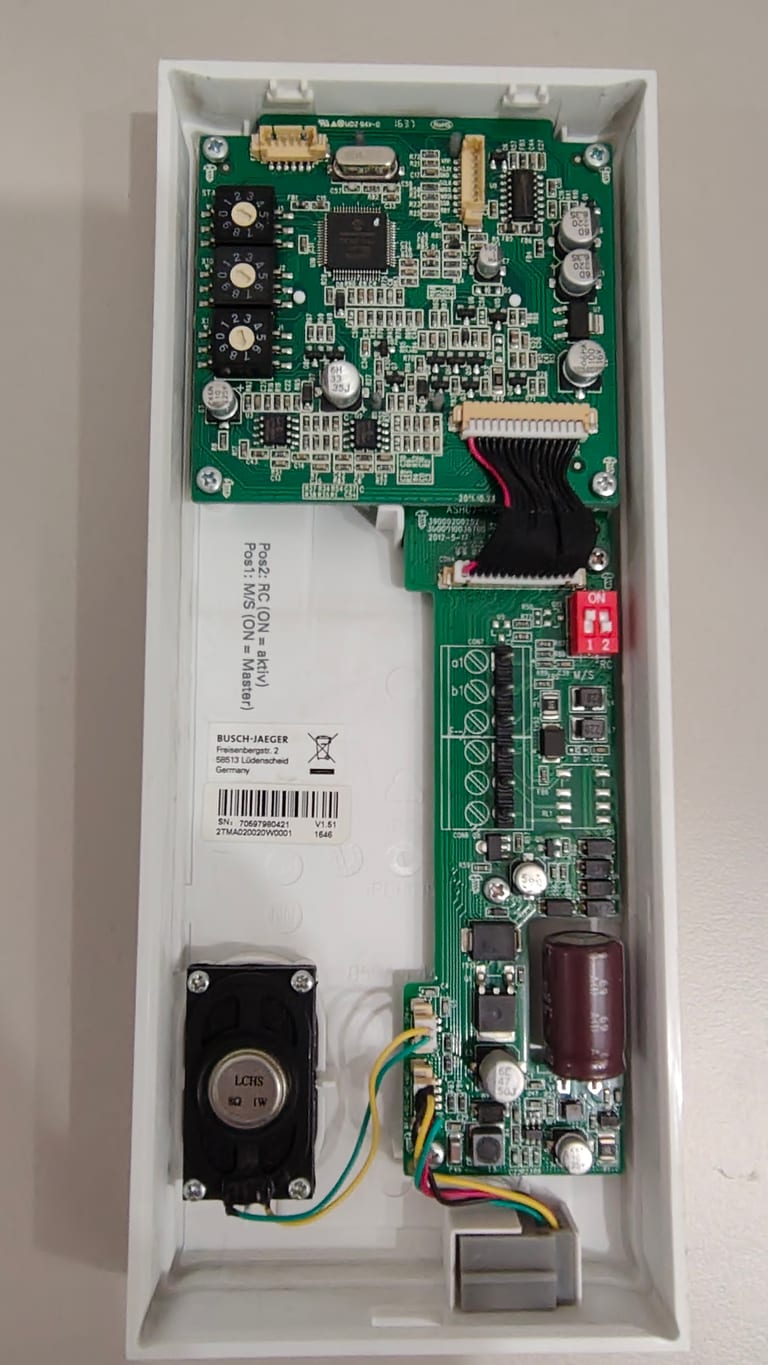 The opened Busch-Jaeger indoor station board with its a1/b1 terminals and three rotary address dials at the bottom left.