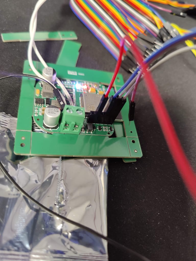 The interface board wired up with jumper cables during testing, status LEDs lit.